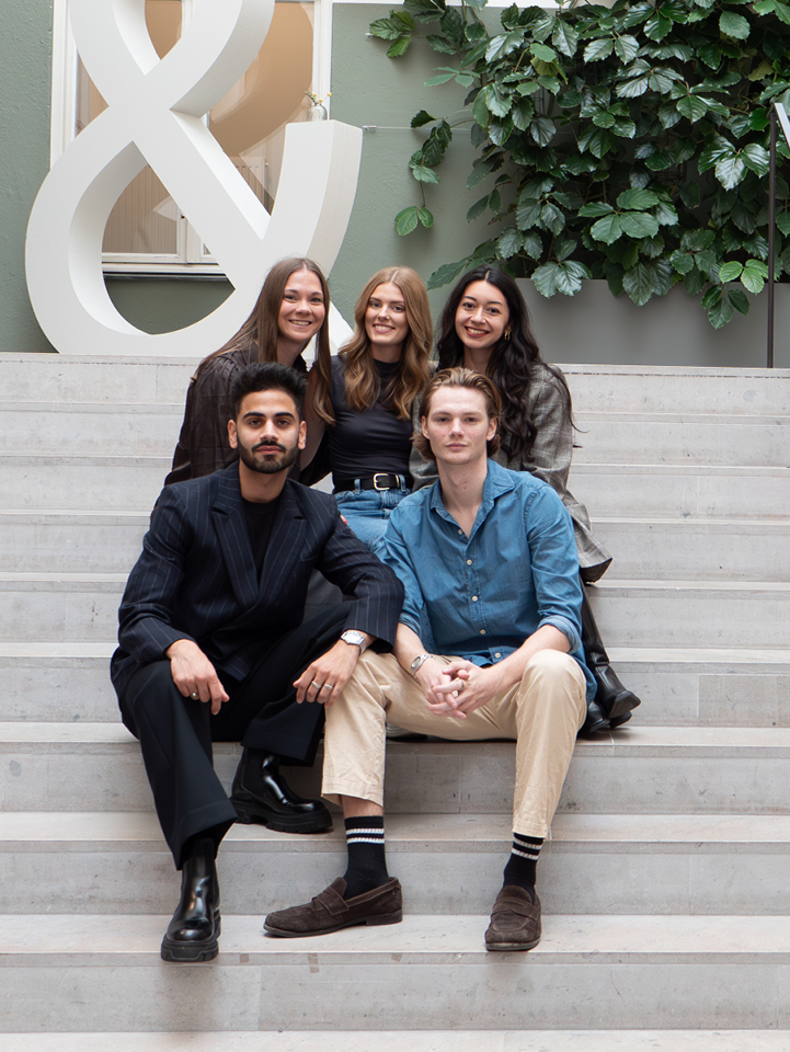 Group photo of trainees sitting on the stairs.