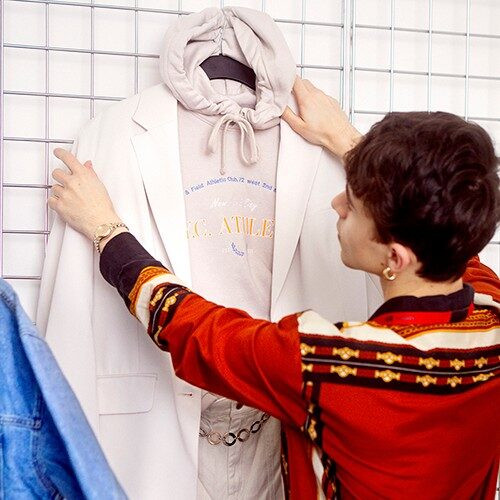 Empleado de tienda masculino arreglando un expositor de ropa