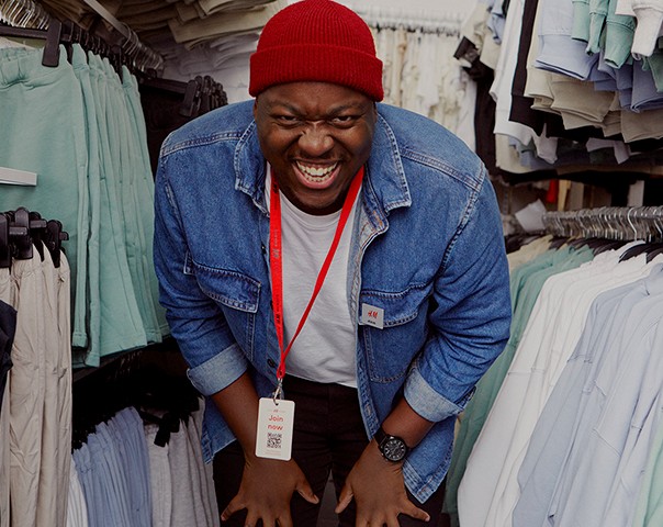 Male store employee bent forward laughing
