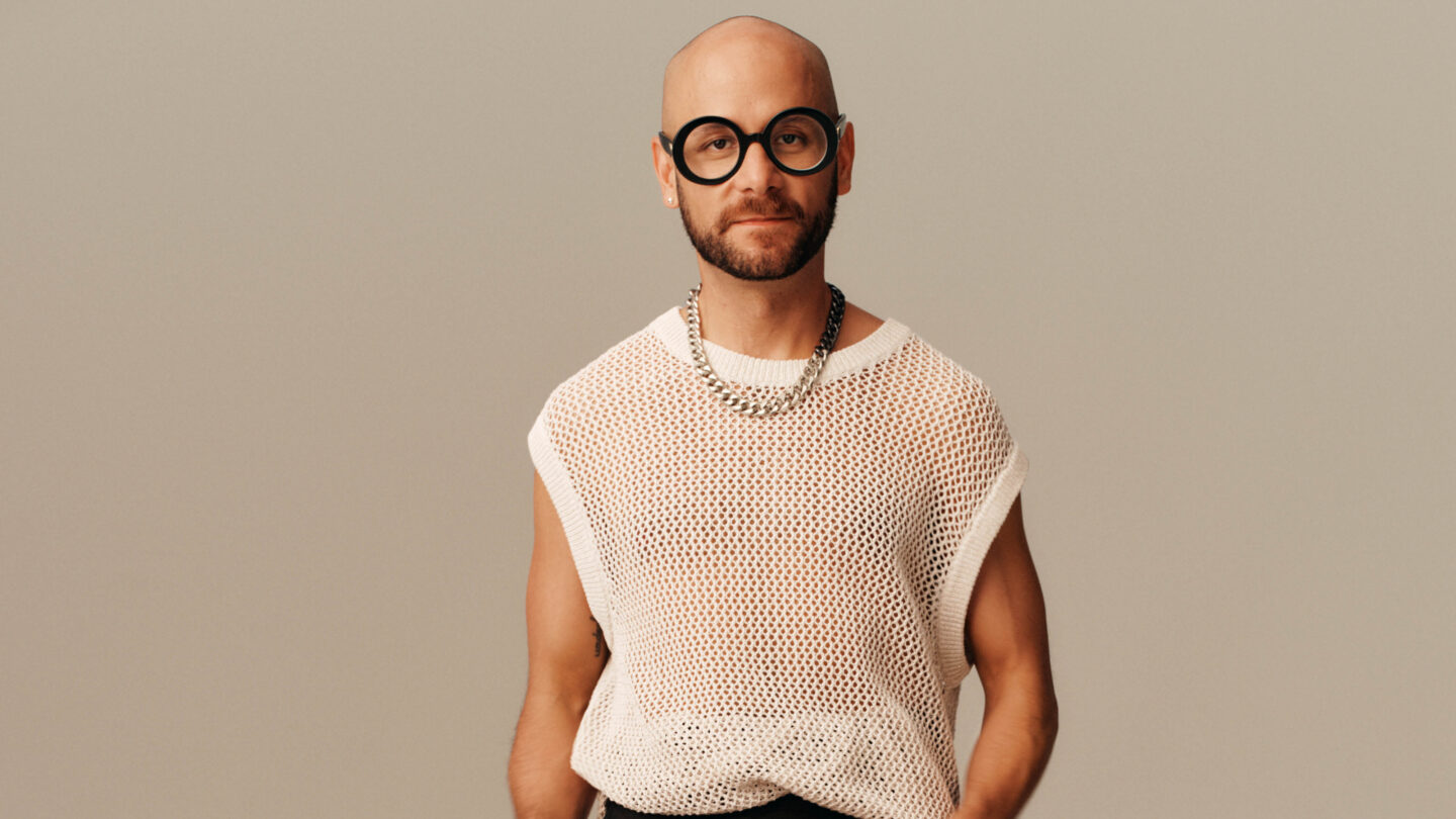 H&M colleague Johan wearing round black glasses and a knitted vest, facing the camera.