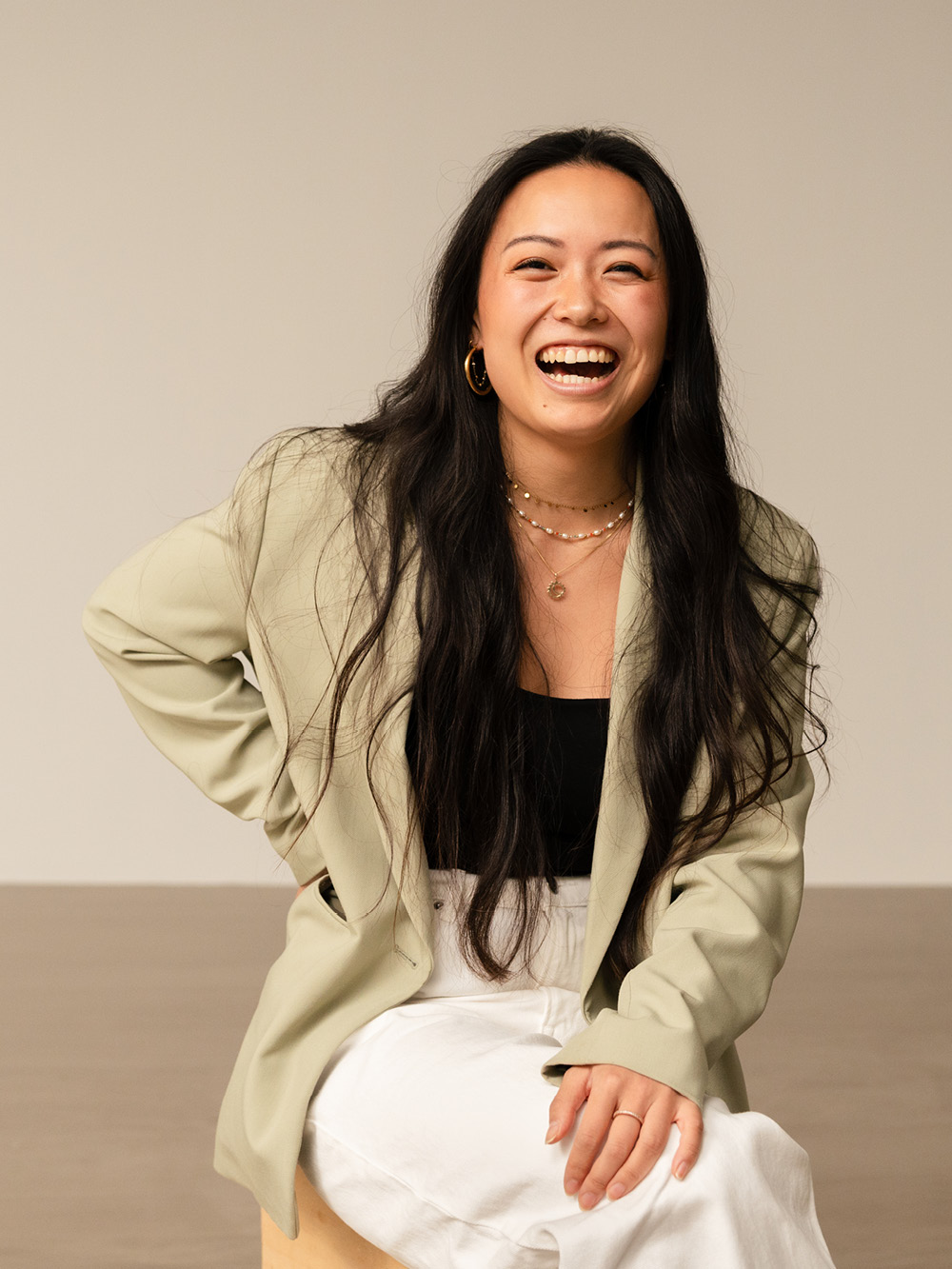 H&M trainee is smiling towards the camera, wearing a green blazer