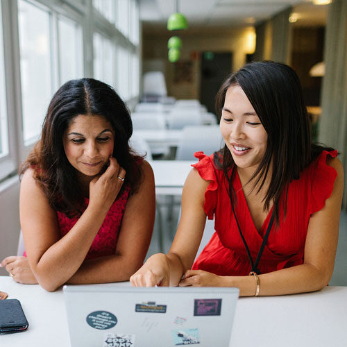 ノートパソコンの画面を見る2人の女性社員