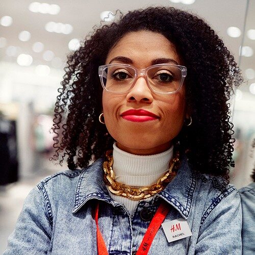 Kvindelig butiksmedarbejder ser på kameraet med et selvsikkert udtryk