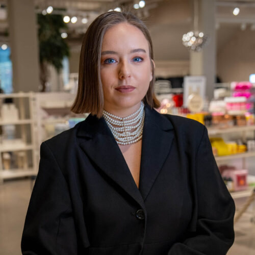 Visual Merchandiser standing in front of H&M Beauty products.