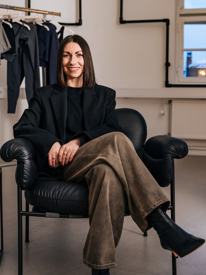 Caroline, H&M Product Developer, sitting on a leather stool